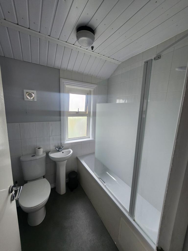 A bright and tidy bathroom suite featuring a wh...